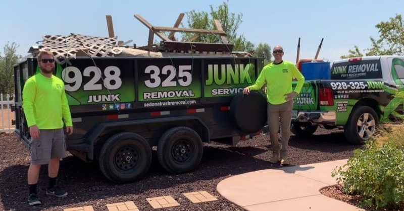 squeaky clean team standing with load of junk inside of junk removal truck